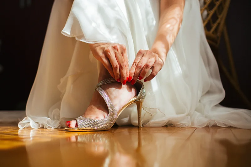 A bride puts on a high heel shoe
