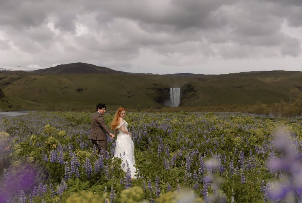 Anna and groom stand in a flowery meadow