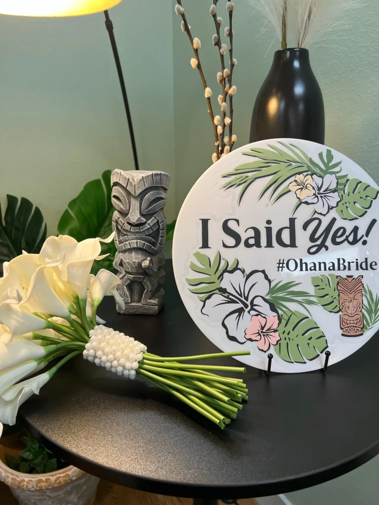 A side table at Ohana bridal featuring a bouquet of lilies and a sign that says "I sad Yes!"