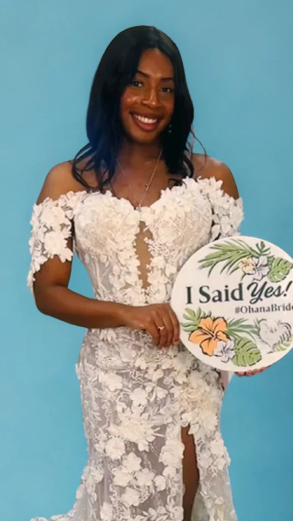 A bride holding a sign that says "I Said Yes!"