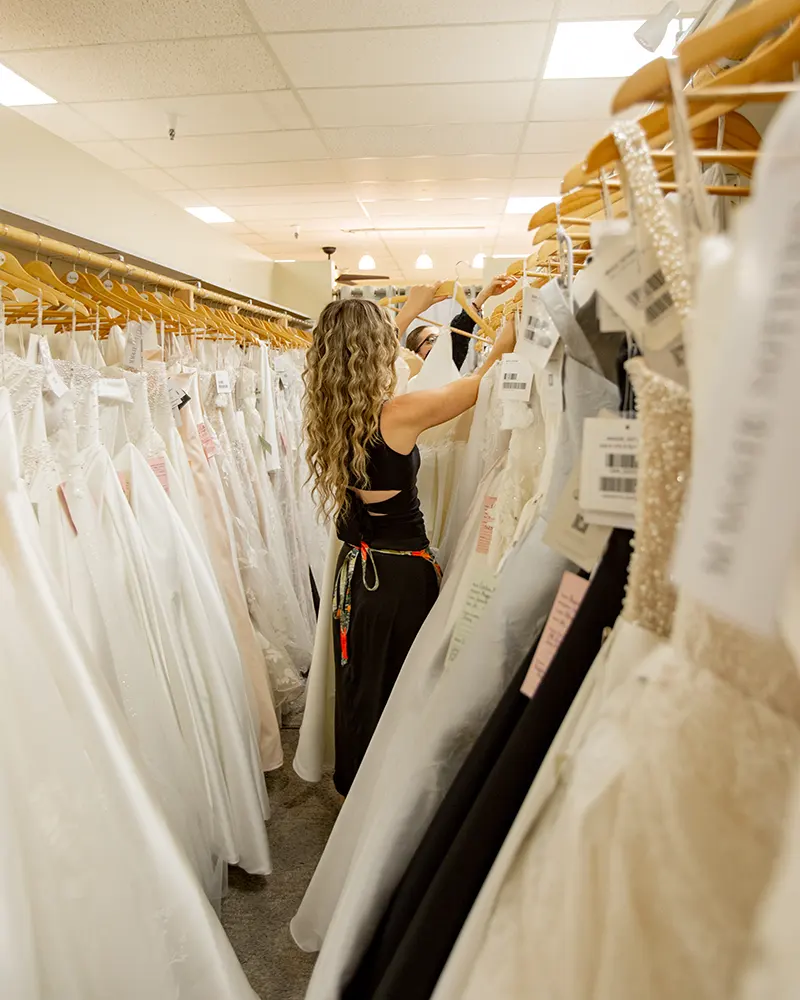 An Ohana employee sorts through wedding dresses