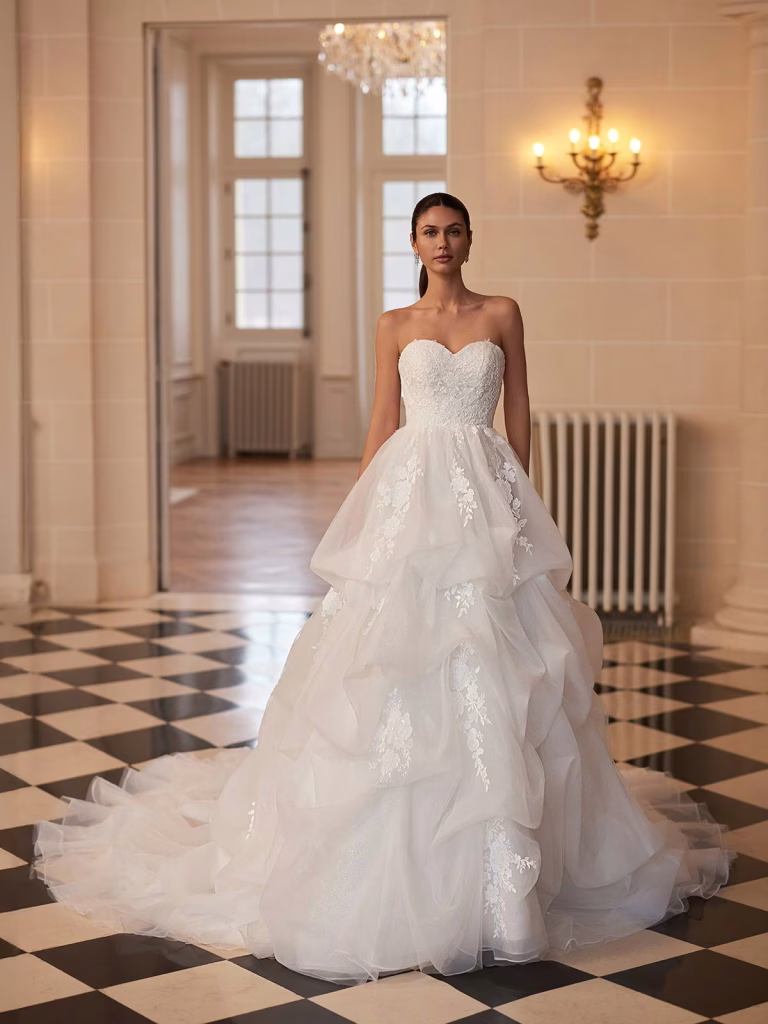 Opaline by Moonlight Couture organza ball gown wedding dress with embroidered lace appliqués, sweetheart neckline, sculptural pickup skirt, V-back, and chapel train.