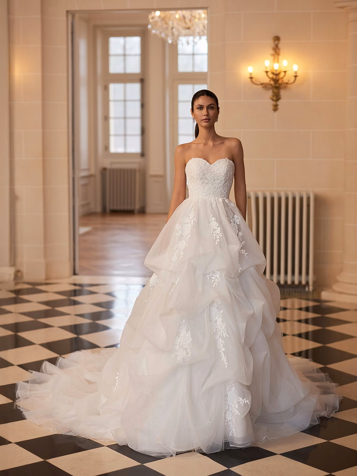 Opaline by Moonlight Couture organza ball gown wedding dress with embroidered lace appliqués, sweetheart neckline, sculptural pickup skirt, V-back, and chapel train.