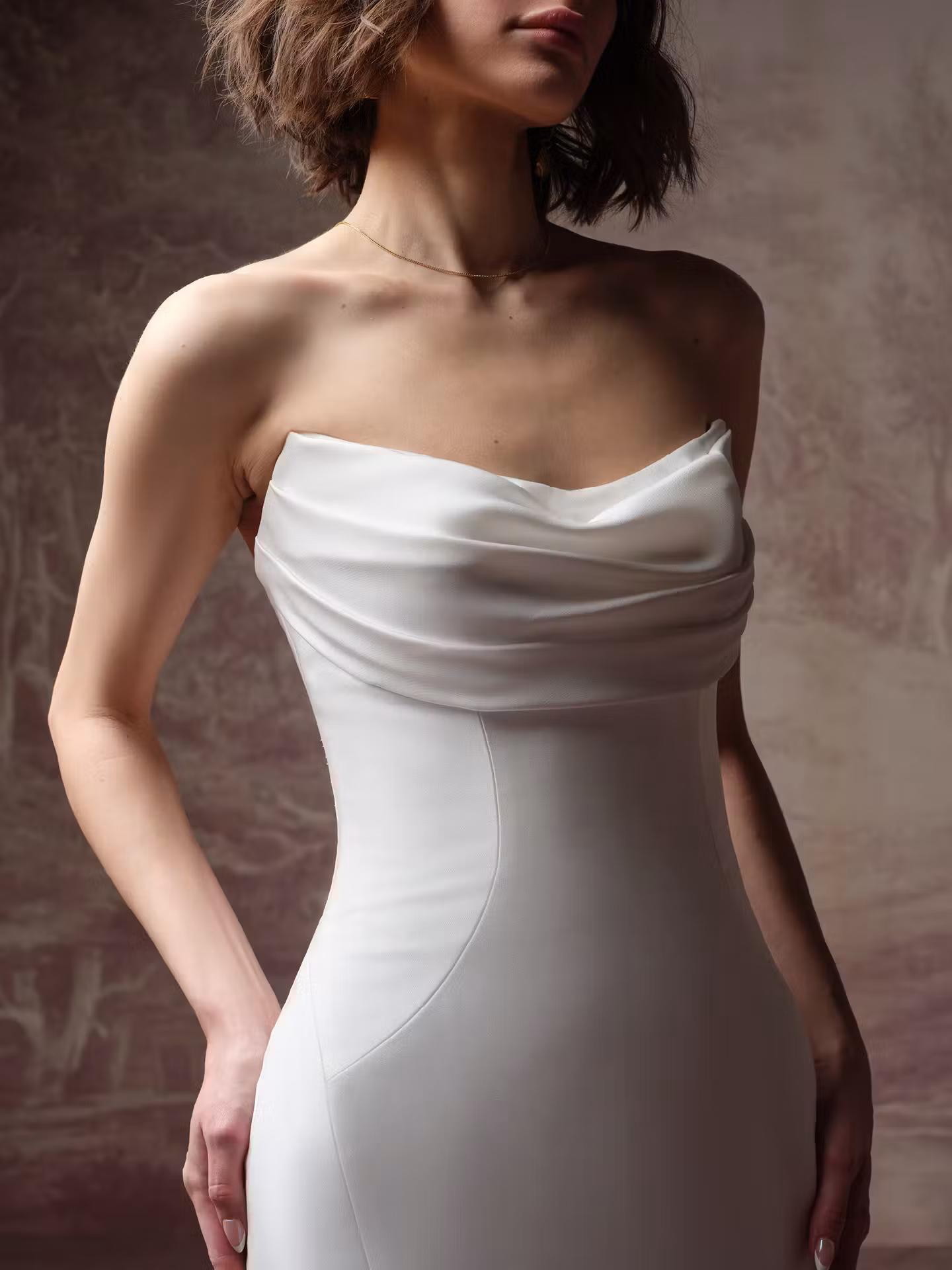 Kayla by Rebecca Ingram draped satin sheath wedding dress featuring a strapless cat eye neckline and elegant fitted silhouette.