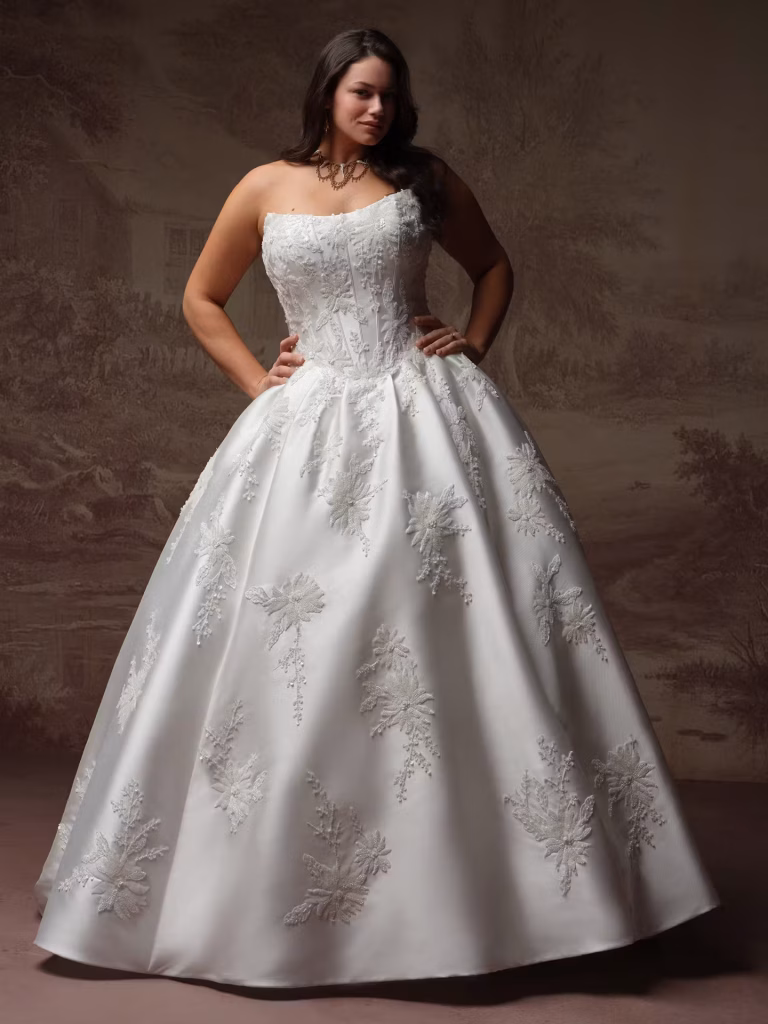 Lucinde by Sottero & Midgley Lyric Mikado ball gown wedding dress with a cat eye neckline, exposed boning, beaded lace appliqués, deep V-back, and hidden pockets.
