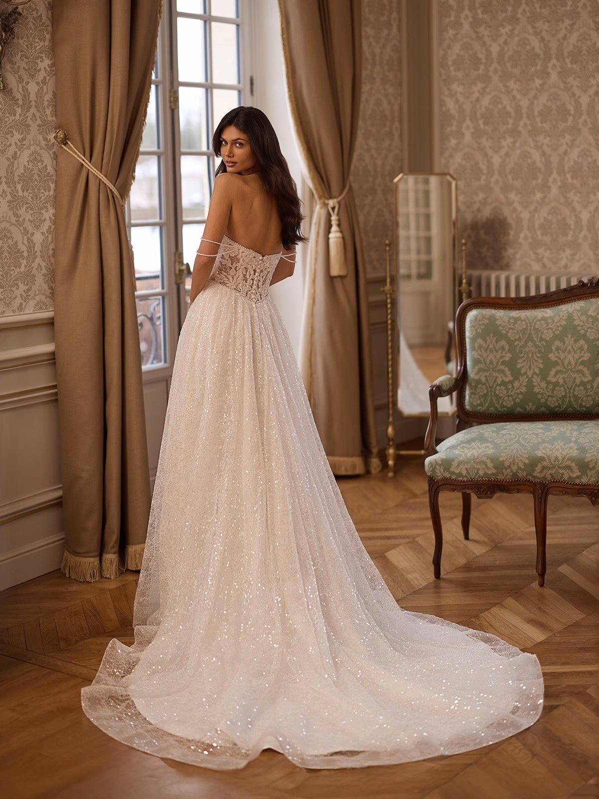 Solstice by Moonlight Couture pearl lace A-line wedding dress with a sweetheart neckline, basque waist, illusion back, shimmering sequins, and detachable pearl swag sleeves.
