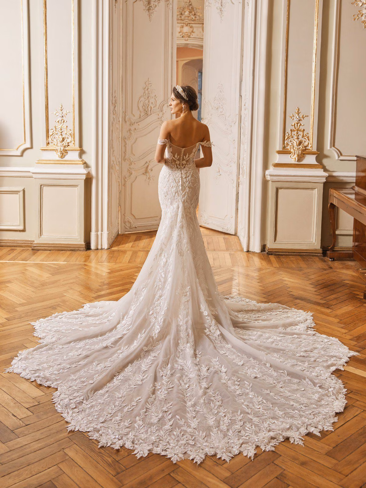 Regent by Val Stefani off-the-shoulder fit and flare wedding dress with 3D floral lace, sweetheart neckline, illusion side cutouts, V-back and cathedral train.