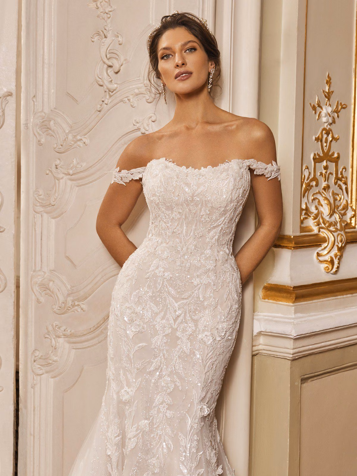 Regent by Val Stefani off-the-shoulder fit and flare wedding dress with 3D floral lace, sweetheart neckline, illusion side cutouts, V-back and cathedral train.